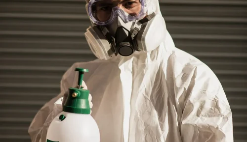 IICRC certified fire damage restoration specialist in full PPE performing emergency smoke odor removal treatment with professional deodorization equipment in Denver